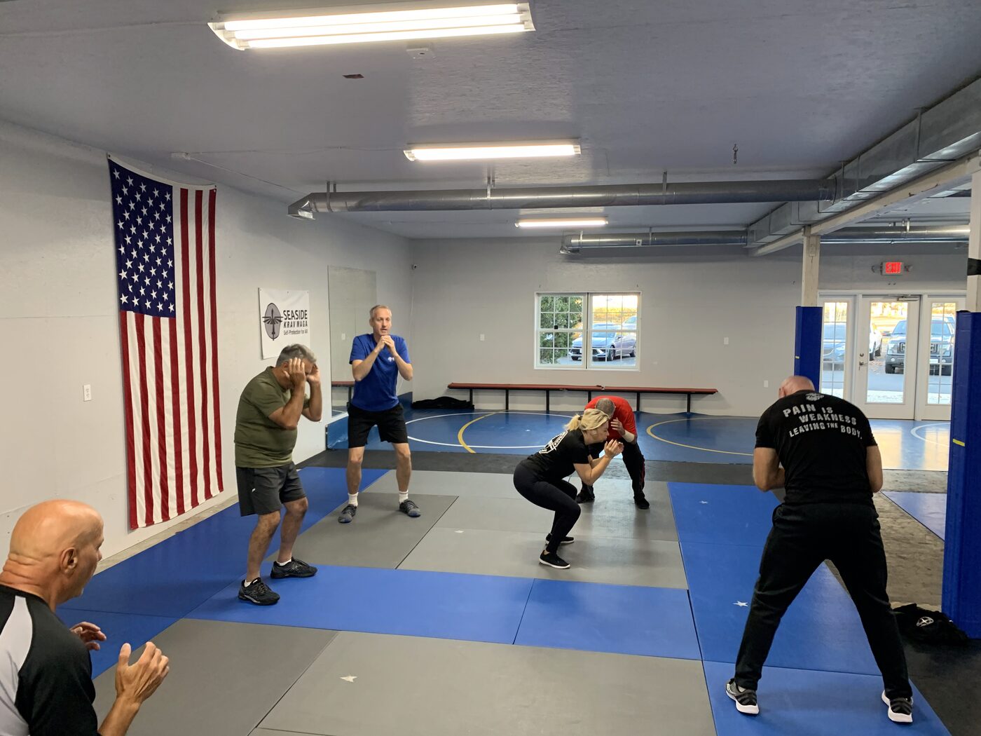 Supervised self-defense scenario practice on the mat at Seaside Krav Maga