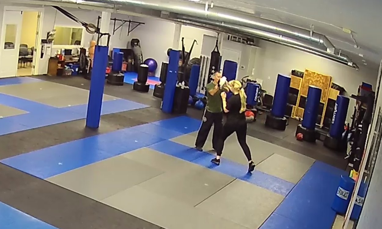 An instructor working one-on-one with a student on close-range self-defense