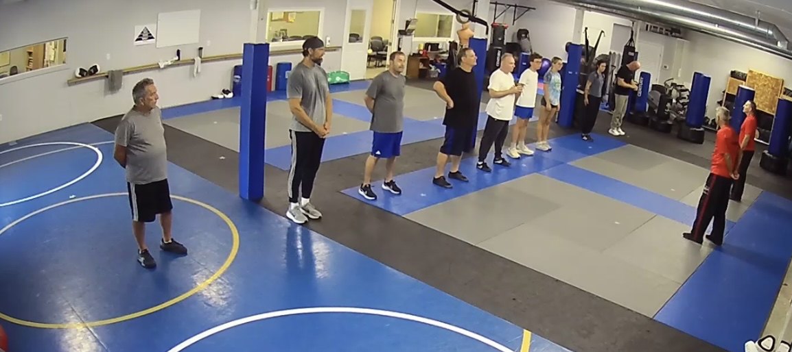A Seaside Krav Maga class lined up on the mat at the start of training